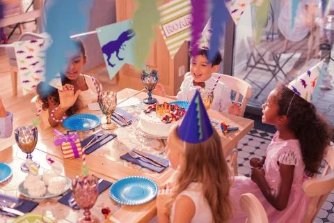 Positive children singing while being at birthday party Stock Photos