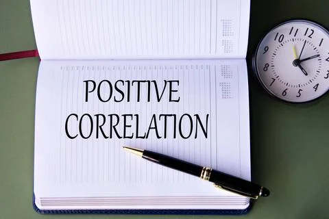 POSITIVE CORRELATION - words in a white notebook on a dark green background.. Stock Photos