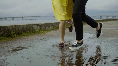 Positive couple dancing on the puddle, smiling and laughing. Attractive woman Stock Footage