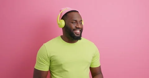 Positive dark skinned guy looks happily away dressed in casual green t shirt Stock Footage 151627730
