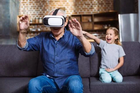 Positive elderly man testing VR device Stock Photos