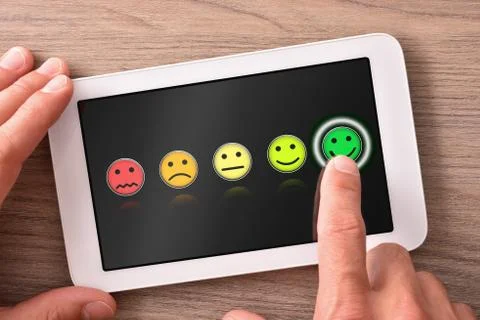 Positive evaluation on tablet with dark background on wooden table Stock Photos