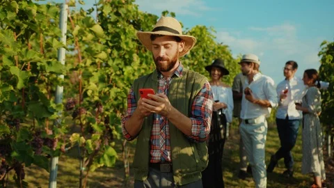 Positive farmer using smartphone calling his friends watching fun videos on Stock Footage 117255755