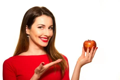 Positive Female Biting a Big Red Apple Fruit Smiling on White Pointing Stock Photos