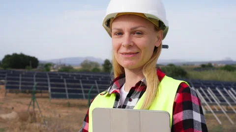 Positive female electrical engineer in safety helmet hold tablet and smilin.. Stock Footage 333581123
