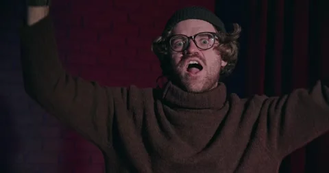 Positive funny guy in turtleneck training his muscles at studio on gradient Stock Footage 264403002