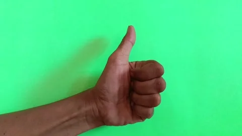 Positive gesture of a thumbs up on a solid green background. Stock Footage 318231835