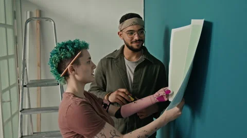 Positive Girl Examining Colour Samples, Boyfriend Pointing at Preferable Hue Stock Footage 323304121