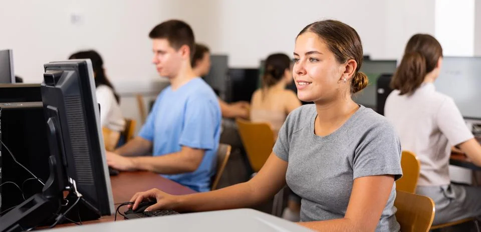 Positive girl using computer in classroom 写真素材