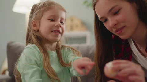 Positive girls look at colored Easter eggs with Ebru design Stock Footage 172365951