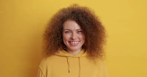 Positive good looking curly haired millennial girl shows goodbye gesture waves Stock Footage 151975467