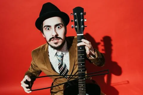 Positive guy playing guitar in the Studio Stock Photos