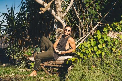 Positive guy sitting under tree Stock Photos