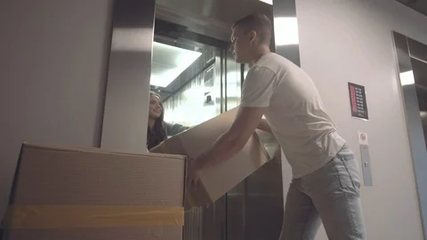 Positive guy takes boxes with things from the elevator Stock Footage 113751820