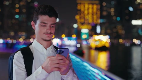 Positive Guy Tourist Browsing in Cellphone, Standing Outside at Night. Stock Footage 256145956