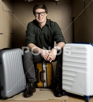 Positive guy is waiting for flight in cardboard room Stock Photos