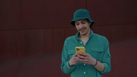 Positive handsome man using smartphone on street Stock Footage 162741895