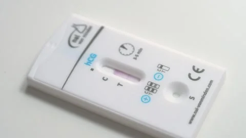 Positive hCG rapid pregnancy test cassette displaying two lines close up Stock Footage 338029984