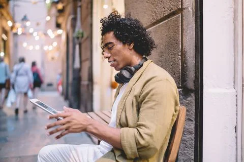 Positive hipster guy checking notification and watching videos via 4G connection Stock Photos