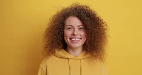 Positive human emotions concept. Cheerful curly haired beautiful young woman Stock Footage 150706357