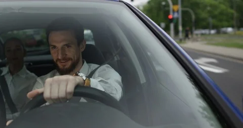 A positive male driver talks to his passenger while driving the uber car Stock Footage 110320557