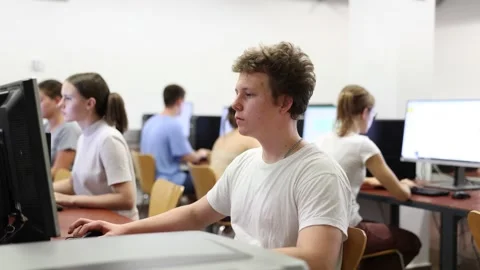 Positive male student using PC and studying computer science in the classroom 스톡 동영상 229600702