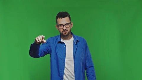 Positive man pointing finger to camera isolated over green background. Choice or Stock Footage 171799066