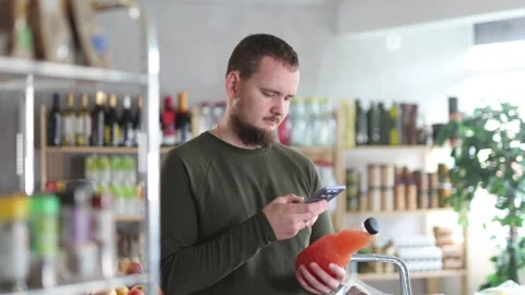 Positive man purchaser scanning QR code or barcode of bottle grapefruit in Stock Footage 332639943