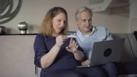 Positive middle aged couple purchasing online together Stock-Footage 101370790