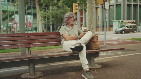 Positive middle-aged man with gray hair and beard wearing casual clothes sits on Stockbeeldmateriaal 226427344