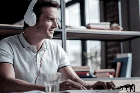 Positive minded man smiling while listening to music Stock Photos