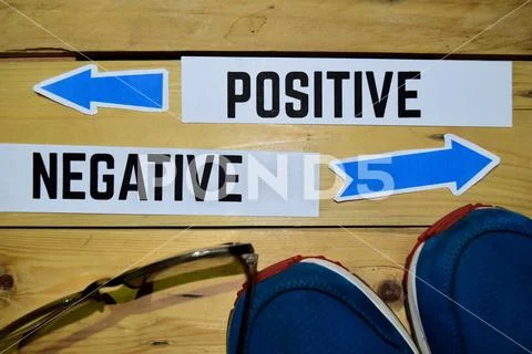 Positive or Negative opposite direction signs with sneakers and eyeglasses Stock Photos