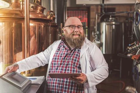 Positive pleasant worker laughing while standing in brew house Stock-Fotos