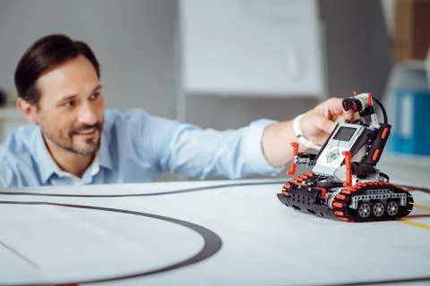 Positive professional engineer testing the robot 스톡 사진