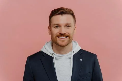 Positive red haired guy on pink background Stock Photos