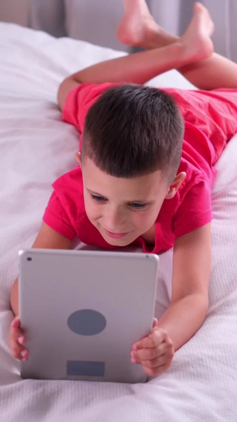 Positive Schoolboy Using Tablet Pc For Online Leisure And Video Games At Home Stock Footage 310453387