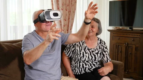 Positive senior couple trying up virtual reality glasses Stock Footage 94208596