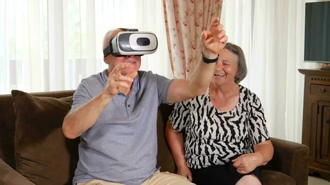 Positive senior couple trying up virtual reality glasses Video stock 102327962