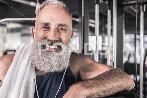 Positive senior male is smiling while standing in athletic center Stock Photos