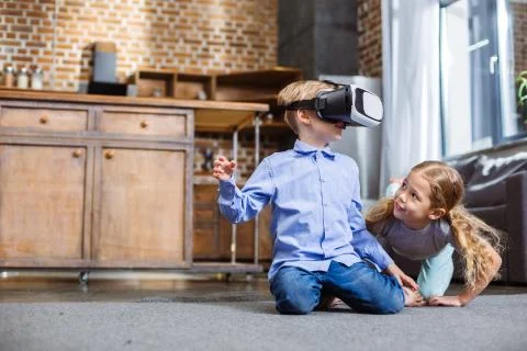 Positive siblings using VR device Stock Photos