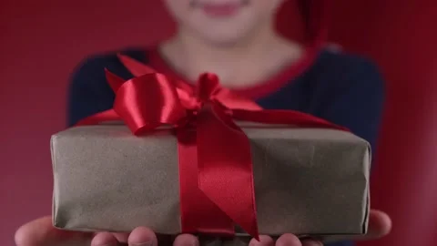 Positive unrecognizable boy wearing santa claus santa hat gives you a gift box Stock Footage 167612609