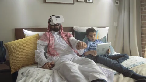 Positive young arab man playing virtual reality game with his son Stock Footage 113749205
