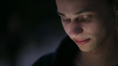 Positive young boy using phone on the street at night Video stock 96217330