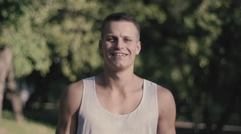 Positive young man on a background of park smiling 240 FPS Stock Footage 54056503
