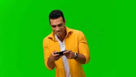 Positive young man playing games on mobile phone. Alpha channel Stock Footage 116786708