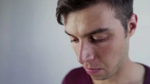 Positive young man smiles to camera playing game on smartphone Stock Footage 208371828