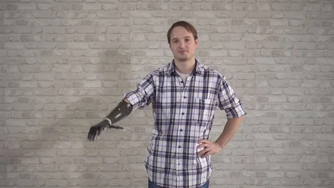 Positive young man waves a cyber prosthetic hand Stock Footage 119072607