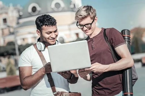 Positive young students using a laptop 스톡 사진