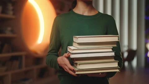 Positive young woman holding stack of books in home study, doing research Stock Footage 340961949