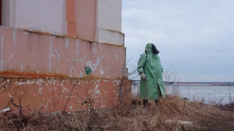 Post-apocalyptic concept - a man in a gas mask wearing protective suit walks Stock Footage 304031808